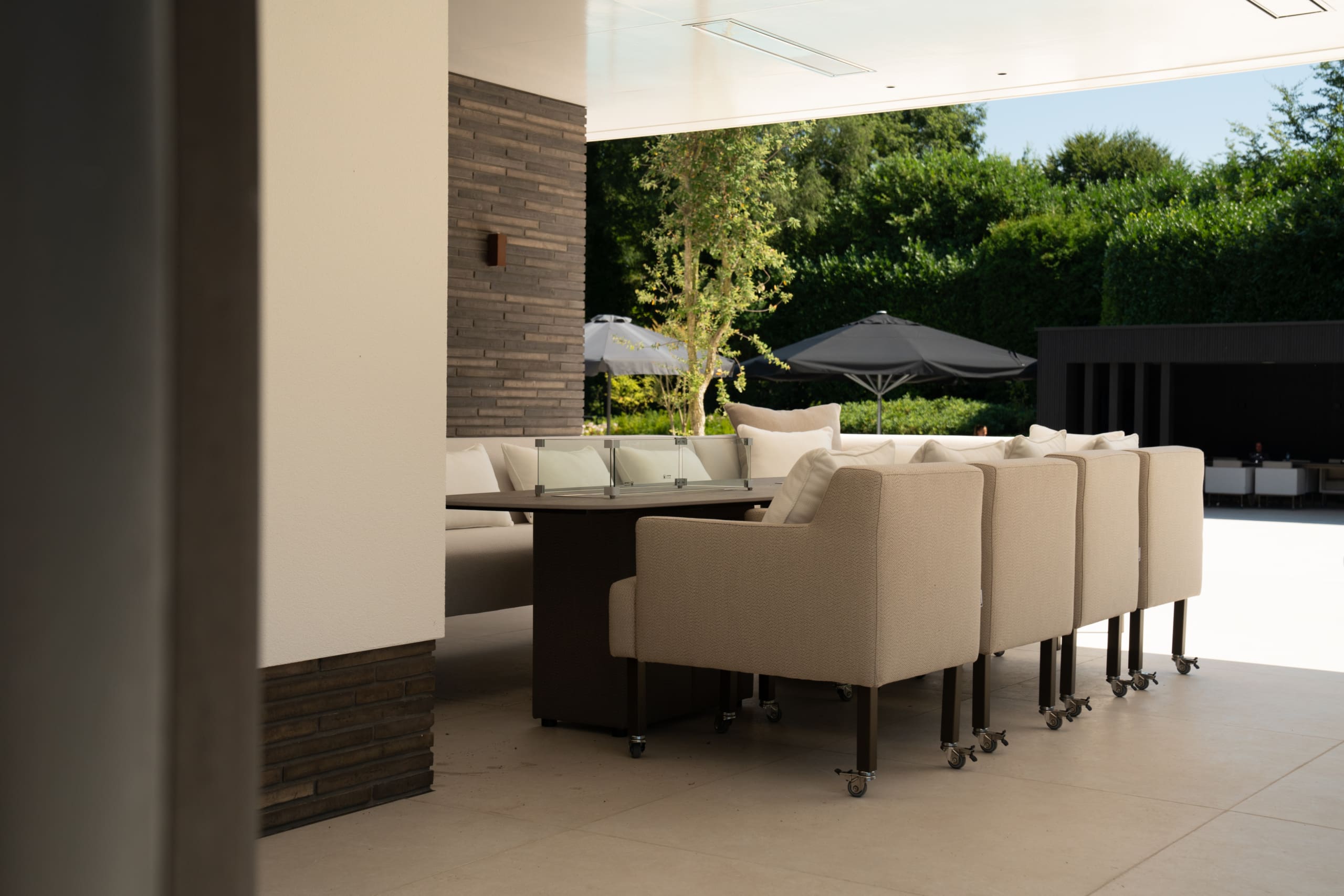 Lange tuintafel op maat met buitenstoelen onder een overkapping